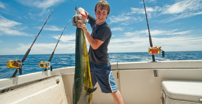 Teen with MahiMahi Dorado or Dolphin Fish on a boat